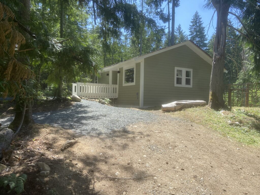 The cottage from a corner angle, with the entrance on the left and side window on the right