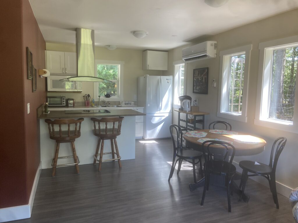 The living/dining room of the Cottage, light shining in through the windows